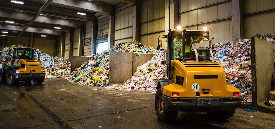 forklifts moving trash at recycling plant